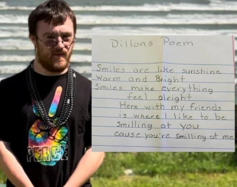 A man poses for a photo. He is wearing glasses and a black shirt decorated with a rainbow peace sign. Edited onto the photo is an image of Dillon's Poem, written on lined paper.