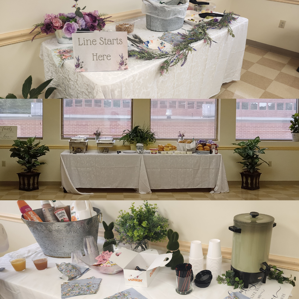 Decorated tables have serving trays of food, juice, coffee, and a sign that says "Line Starts Here" on them.