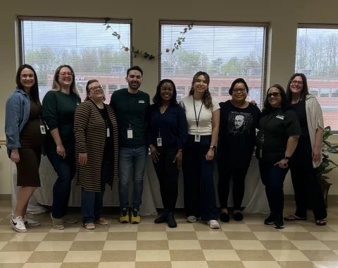 Nine people pose for a photo.