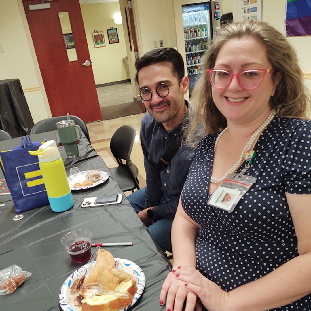 A woman and a man in glasses smile at the camera.