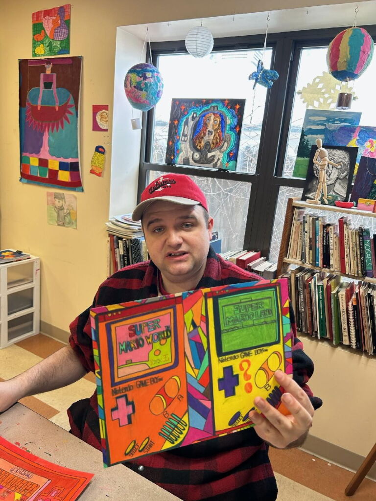 Headshot Nick, a student in living resources arts program for individuals with disabilities holds up a project he completed.